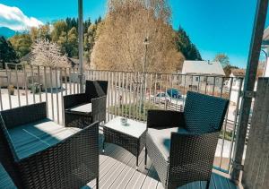 布里克斯萊格的住宿－AlpenLuxus' ALTE MÜHLE LOFT with balcony & car park，阳台配有椅子和一张桌子,位于甲板上
