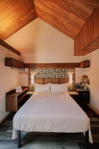 a bedroom with a large bed and wooden ceilings at Suwa Villa Arenal in Fortuna