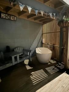 a bathroom with a tub on a wooden floor at The SeaHouse in Kerikeri