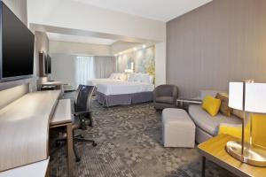 a hotel room with a bed and a living room at Courtyard by Marriott St. Joseph-Benton Harbor in Benton Harbor