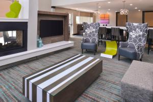 a living room with a fireplace and a dining room at Residence Inn by Marriott Cedar Rapids South in Cedar Rapids