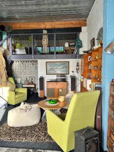 a living room with green chairs and a table at The SeaHouse in Kerikeri