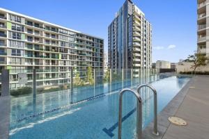a large swimming pool with two tall buildings at Convenient Modern 2Bed Apt Near Airport in Sydney