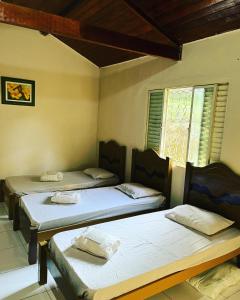 Zimmer mit 3 Betten und einem Fenster in der Unterkunft Espaço Benviver in Guaratinguetá