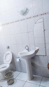 La salle de bains est pourvue d'un lavabo et de toilettes. dans l'établissement Casa - Temporada, à Praia Grande