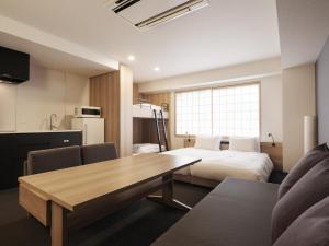 a room with a bed and a table and a kitchen at MIMARU TOKYO NIHOMBASHI SUITENGUMAE in Tokyo