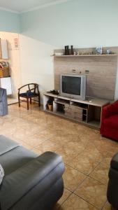 - un salon avec une télévision sur une table dans l'établissement Casa - Temporada, à Praia Grande