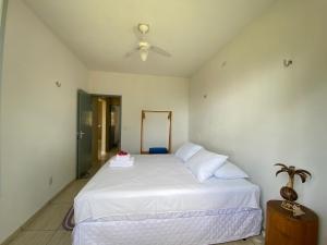 a bedroom with a white bed with a ceiling fan at Casa Praia a Beira Mar Guriú Ceará in Guriú