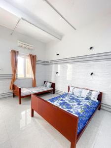 a bedroom with two beds and a window at Kim Long Hotel in Phan Thiet