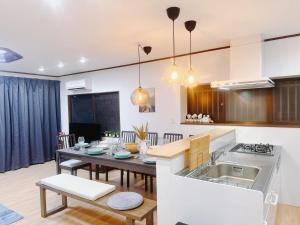 a kitchen and living room with a table and a kitchen and a dining room at Retreat Tengachaya 旅趣 天下茶屋 in Osaka