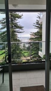 a sliding glass door with a view of the ocean at SUNSET GETAWAY GLENELG in Glenelg