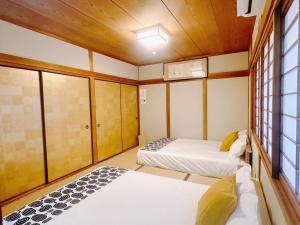 a room with two beds and a window at Retreat Tengachaya 旅趣 天下茶屋 in Osaka