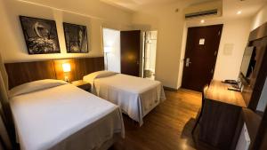 貝洛奧里藏特的住宿－Hotel Vivenzo Savassi Belo Horizonte，酒店客房设有两张床和电视。