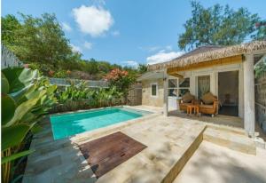 a backyard with a swimming pool and a house at Ora Villas Gili Meno in Gili Meno