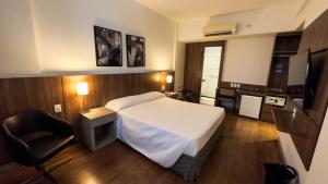 a hotel room with a bed and a television at Hotel Vivenzo Savassi Belo Horizonte in Belo Horizonte