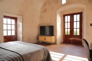 a bedroom with a bed and a flat screen tv at Estancia El Solar in Arequipa
