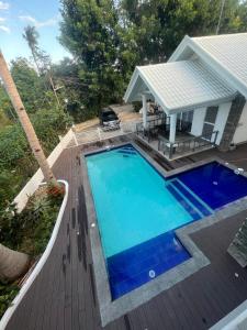 a swimming pool on a deck next to a house at Grande Villa in Panglao