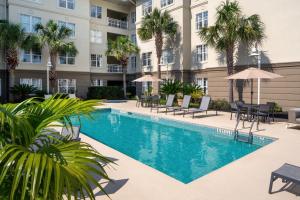 a swimming pool in front of a building with palm trees at Residence Inn Charleston Riverview in Charleston