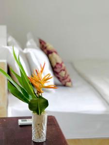 a vase with an orange flower on a table at Tarci Bungalows Lembongan in Nusa Lembongan