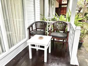 two chairs and a table on a porch at Tarci Bungalows Lembongan in Nusa Lembongan