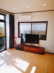 a living room with a large flat screen tv at Retreat Tengachaya 旅趣 天下茶屋 in Osaka