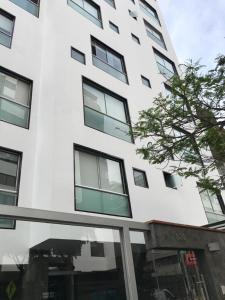 un edificio alto y blanco con ventanas. en Apartamento en Miraflores La paz, en Lima