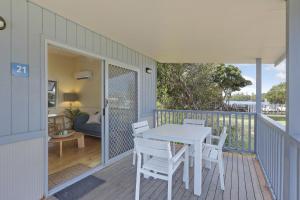 a patio with a table and chairs on a deck at Reflections Lennox Head - Holiday Park in Lennox Head