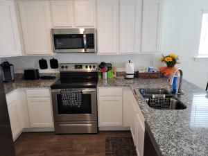 a kitchen with a stainless steel stove and a microwave at SC 3745 New Townhouse Ft Jackson & USC in Columbia