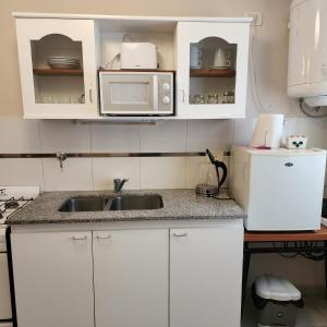 ラプラタにあるLa constanciaの白いキャビネット、シンク、電子レンジ付きのキッチンが備わります。