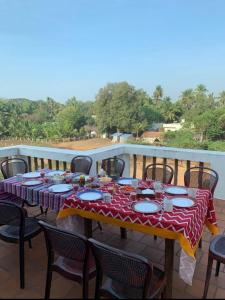 a table with a red and white table cloth on a balcony at Tranquility Guest House in Srīrangam