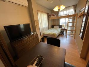a living room with a television and a table at まちやど　Motomachi in Daigo