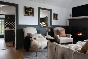 a living room with two chairs and a fireplace at Innisfree in Daylesford