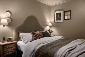 a bedroom with a bed and two lamps and a clock at Innisfree in Daylesford
