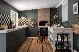 a kitchen with dark green walls and bar stools at Innisfree in Daylesford +9 photos