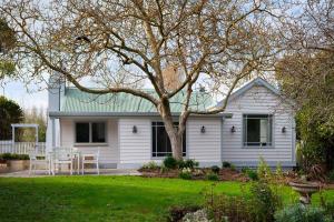 a white house with a tree in the yard at Innisfree in Daylesford