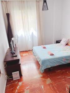 a bedroom with a bed and a desk with a lamp at 3 Habitación centro Huelva in Huelva