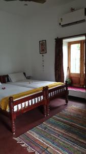 łóżko w sypialni z drewnianą ramą w obiekcie Tranquility Guest House w mieście Srirangam