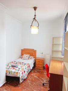 a bedroom with a bed and a desk and a chair at 3 Habitación centro Huelva in Huelva