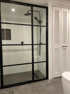 a glass shower in a bathroom with a toilet at Il Palazzo Holiday Apartments in Cairns