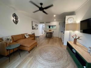 a living room with a couch and a ceiling fan at Il Palazzo Holiday Apartments in Cairns