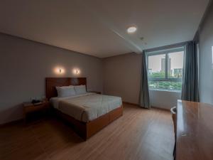 a bedroom with a bed and a large window at MIRAFLORES CITY HOTEL in Lima