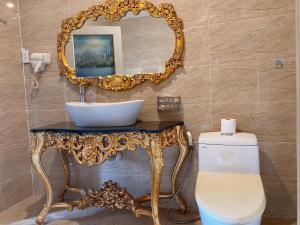a bathroom with a sink and a mirror over a toilet at CROWNE BUI VIEN Hotel in Ho Chi Minh City