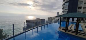 a swimming pool on top of a building next to the ocean at Euromarina GranVistaMar in Viña del Mar