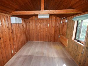 a small room with wooden walls and a wooden floor at Tonosaki Bungalow & BBQ in Tsushima