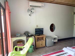 a room with a desk with a computer and a fan at Phuchomjan Resort in Mae Hong Son