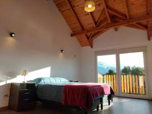 1 dormitorio con cama y ventana grande en Casa Cerro Ventana Bariloche 2 en San Carlos de Bariloche