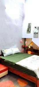 1 dormitorio con 1 cama con colchón verde en H2Homestay phố cổ check in tự động en Hanói