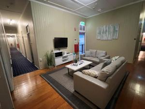 a living room with a couch and a tv at Biloela Hotel in Biloela