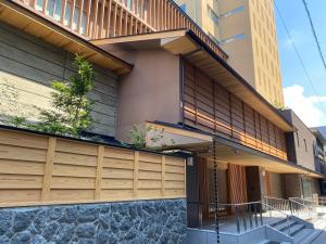 une façade d'un bâtiment avec des portes de garage en bois dans l'établissement Ryokan Ginkaku Kyoto, à Kyoto