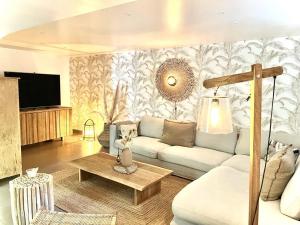 a living room with a couch and a tv at Maison en pierre avec piscine, 6 couchages, située au cœur de Mallemort, Provence. - FR-1-658-25 in Mallemort